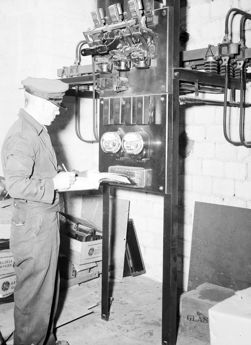 Un lector de contadores anota a mano la lectura de los contadores eléctricos en 1952.
